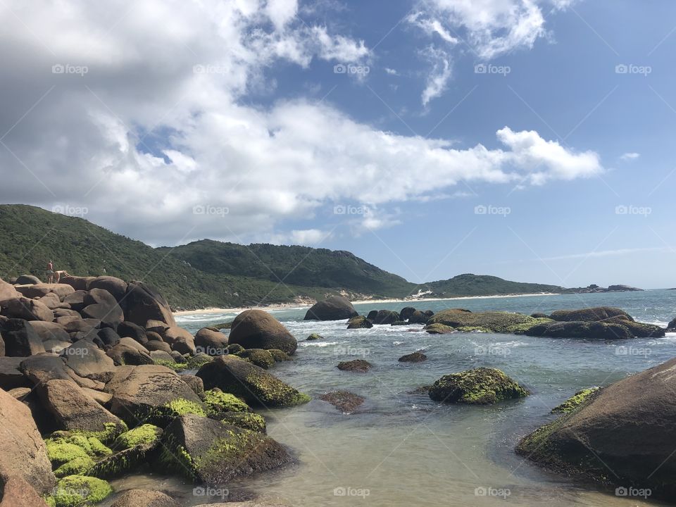 Rock on the sea with beach behind