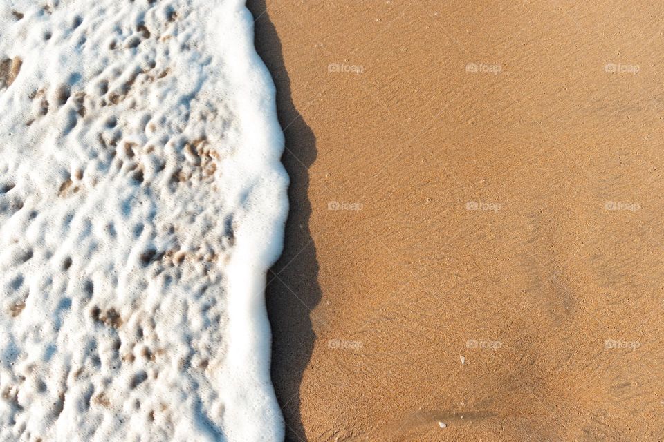 Beautiful white waves crashing on to the golden sandy beach. Perfect beach vibes in the eastern coast of the tropical paradise Sri Lanka.