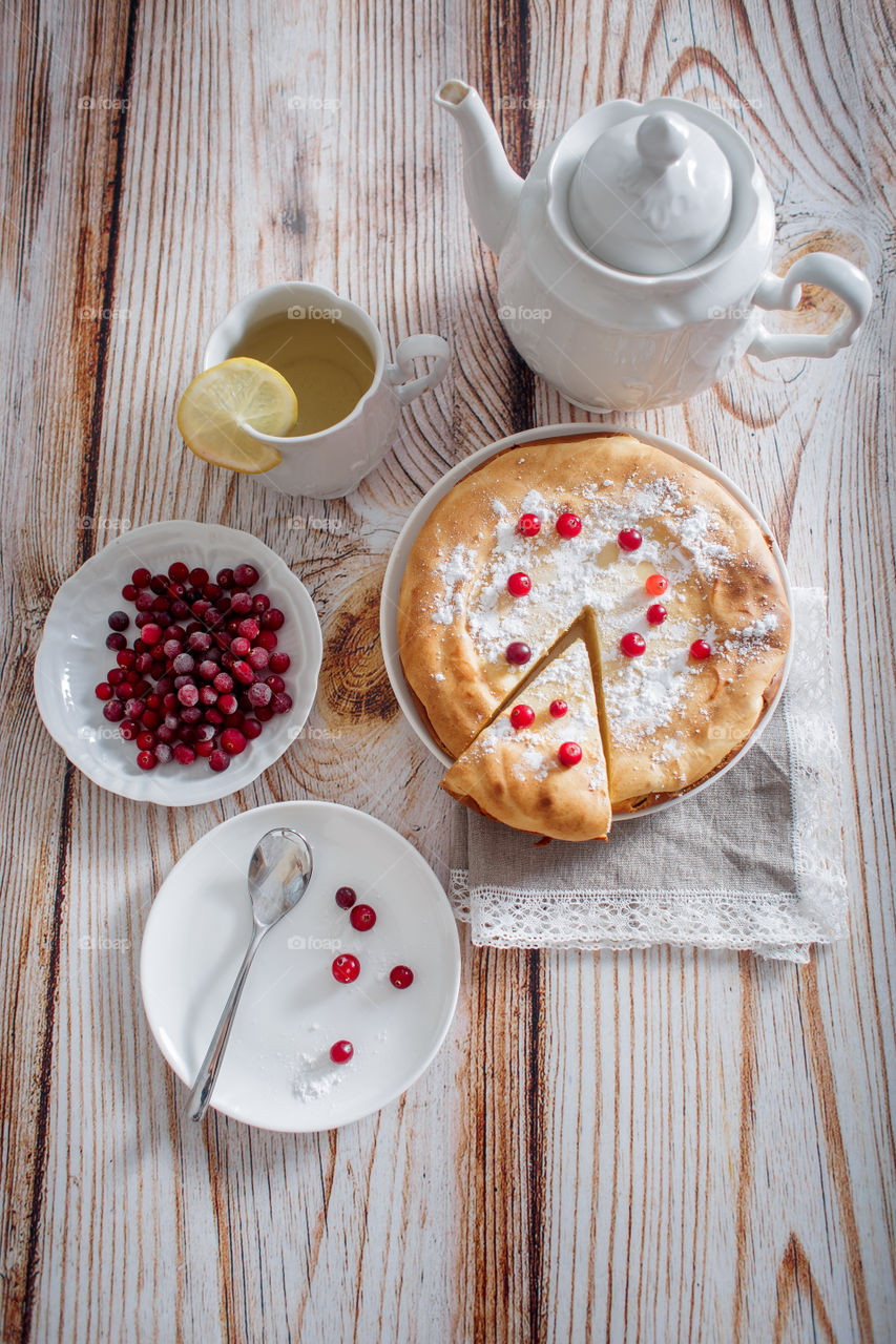 Cheesecake with cranberries and sugar on wooden background