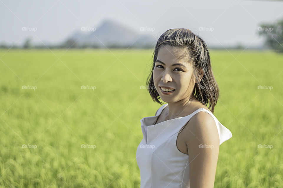 Portrait of a Asean Woman Background Blurry rice fields and mountains.