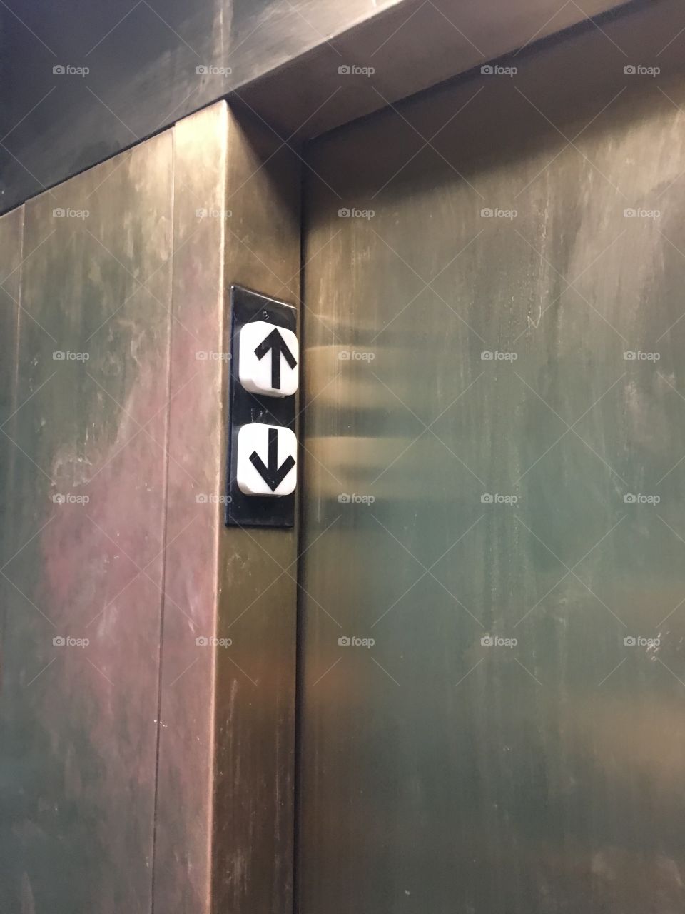 Directional arrows outside a gold elevator