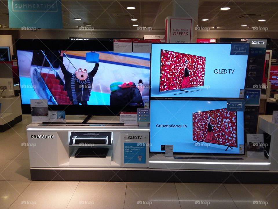 Samsung QLED ambient mode TV wall mounted televisions 4K Ultra High Definition on comparison wall with blu-ray player at Peter Jones department store Sloane square Chelsea Kings road London