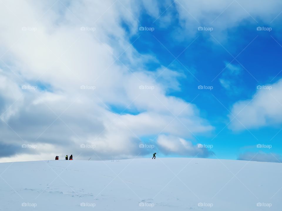 skiers in the distance on the snowy mountain