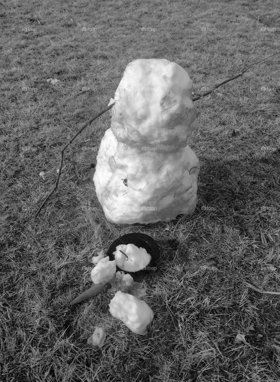 Melting snowman on the grass