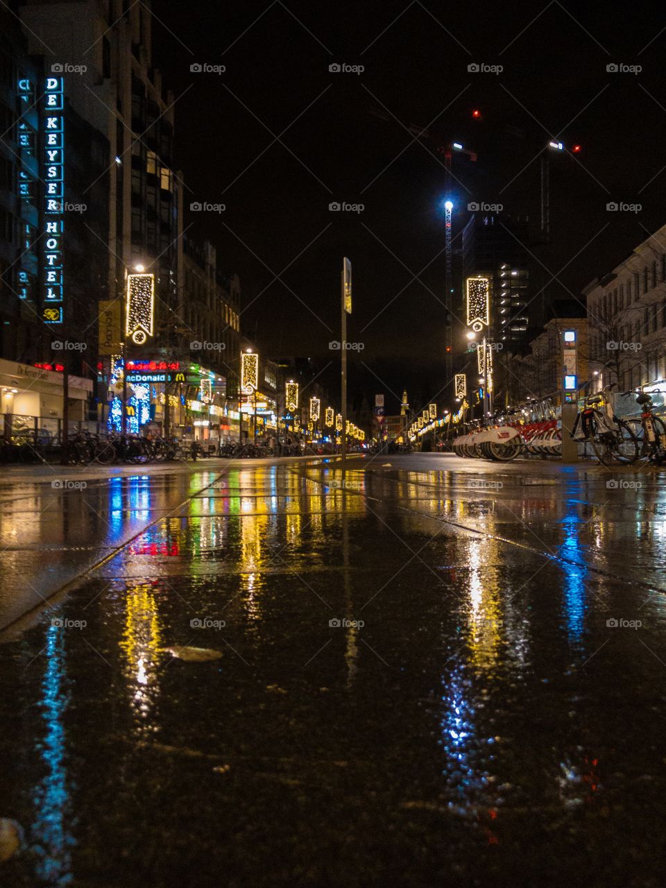 shopping street in the city with colorful neon lights at night reflected on the wet street 