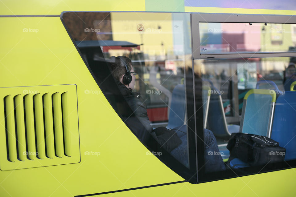 boy with a headphones on yellow bus. boy on a yellow bus with head iPhones and the glasses 