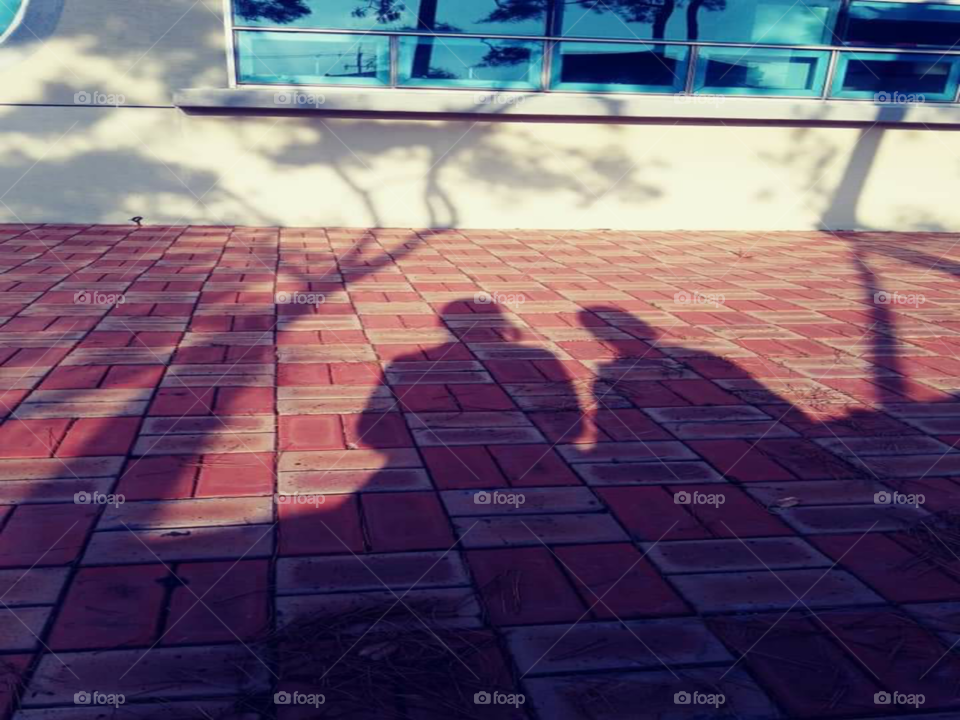 shadow of a mother and child sitting in the chair  together.