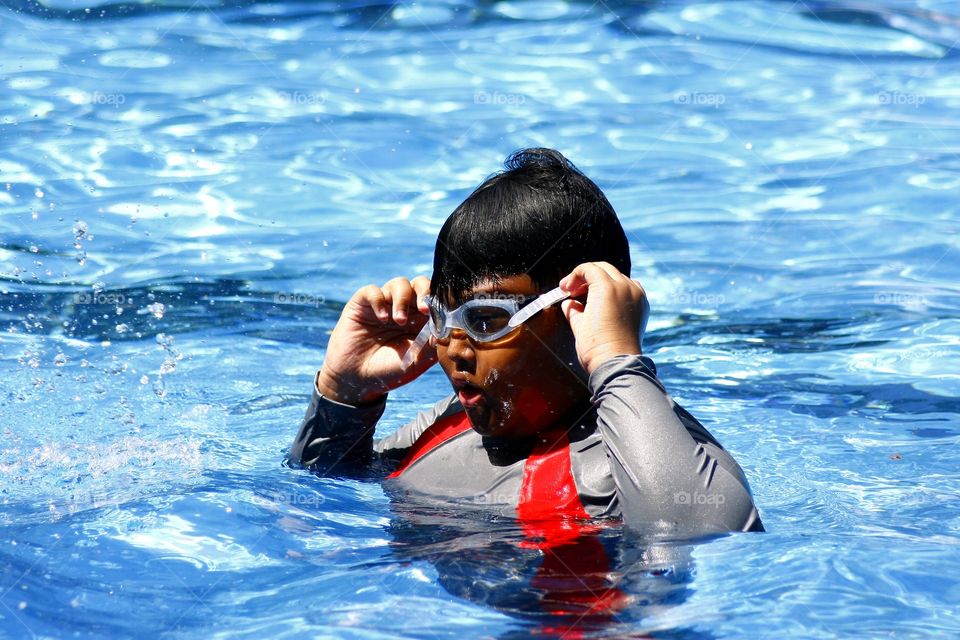 boy fixing his swimming goggles