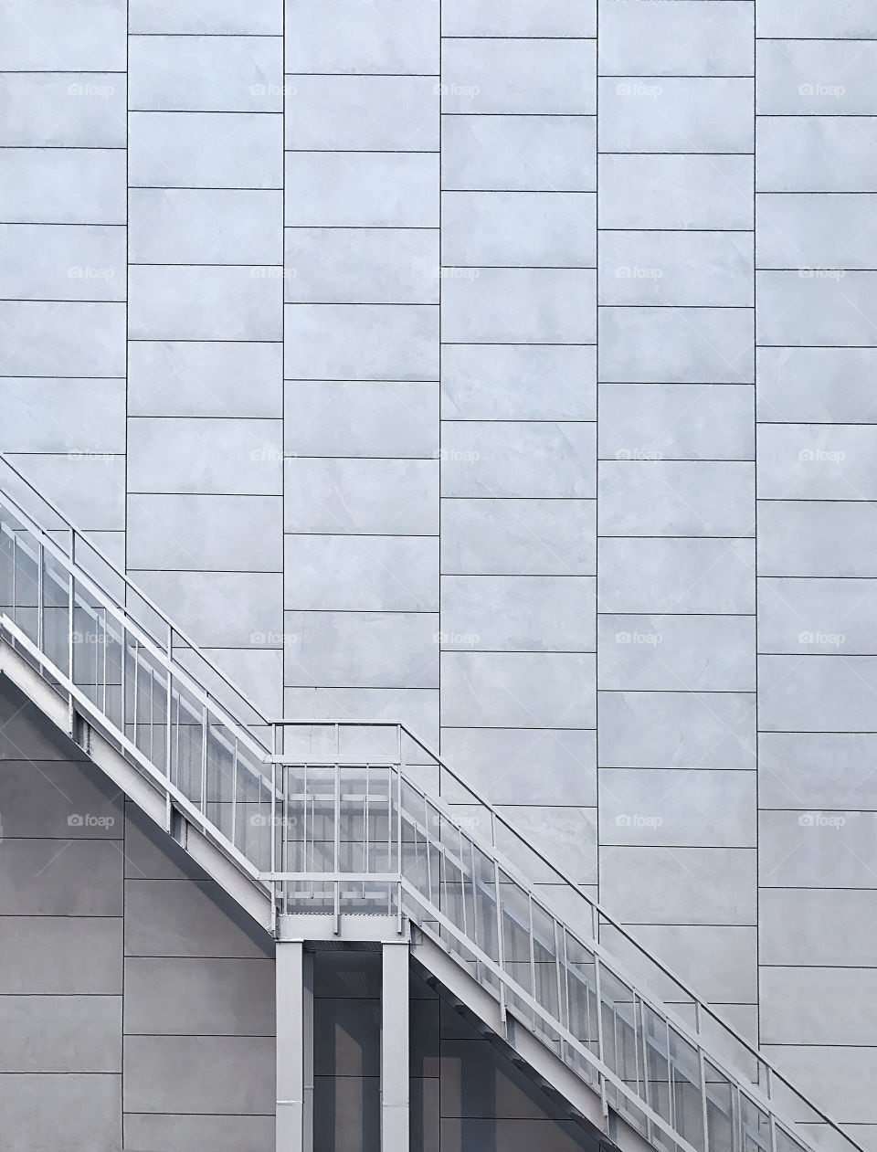 Minimal architecture concept of metal stairs in front of geometric monochrome brick wall 