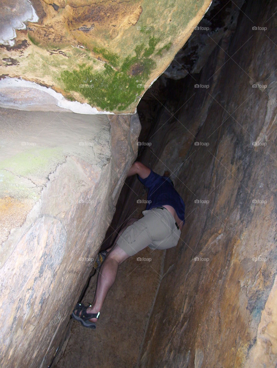 climbing in tight spaces. husband climbing in between rocks