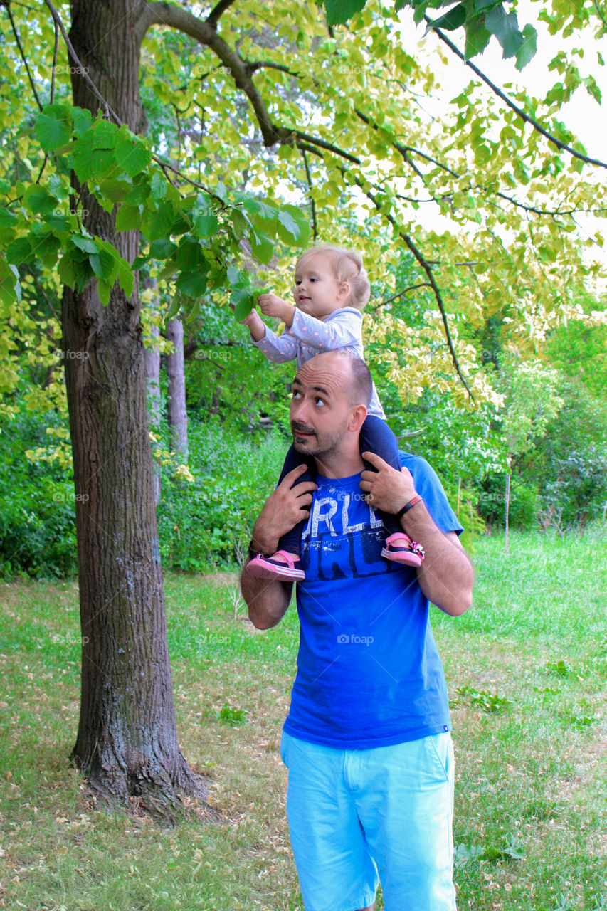 Father carrying his daughter on shoulder