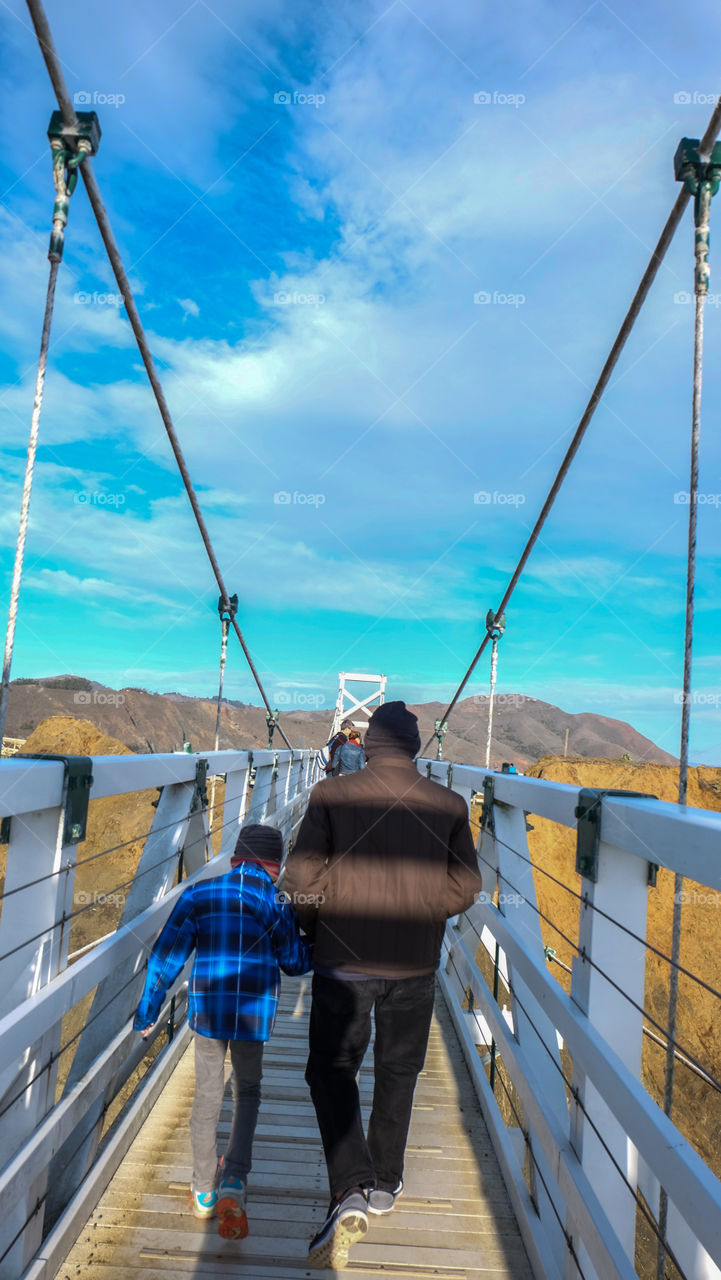 People walking on a white foot bridge