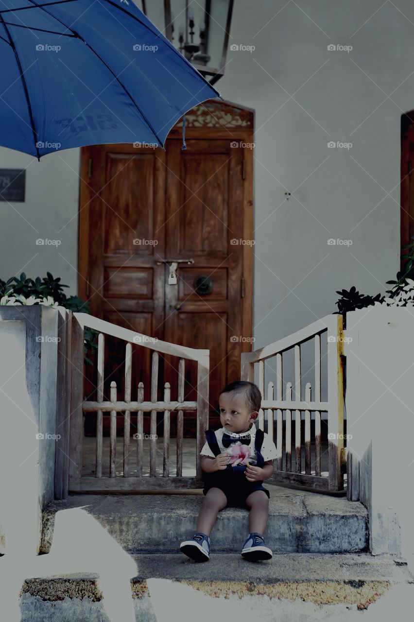 little boy covered by umbrella shadow 