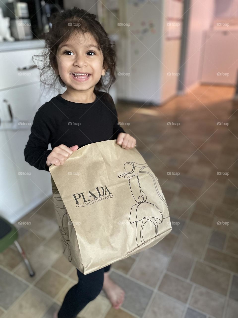 Piada Italian Street Food delivery, getting food delivered, delivering food from Piada, toddler holds bag of Piada food, DoorDash delivery service