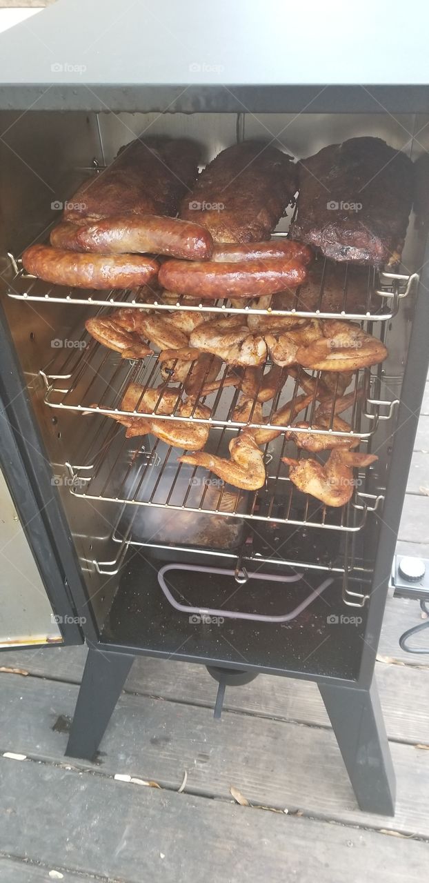 Electric smoking chicken wings and sausage and ribs on New Years