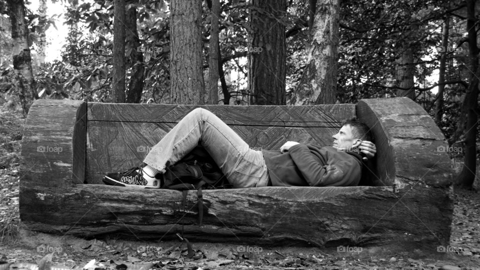 Mature man lying on wooden bench