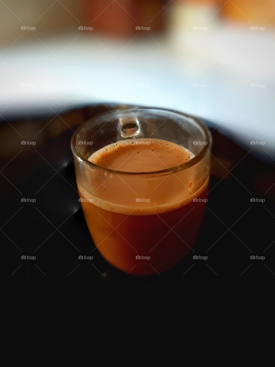 A cup of coffee on the black glass round table