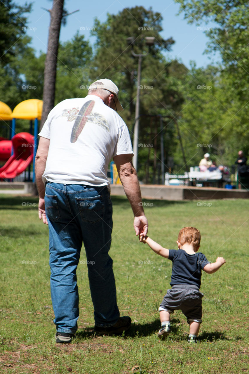 Grandpa helping his grandson walk