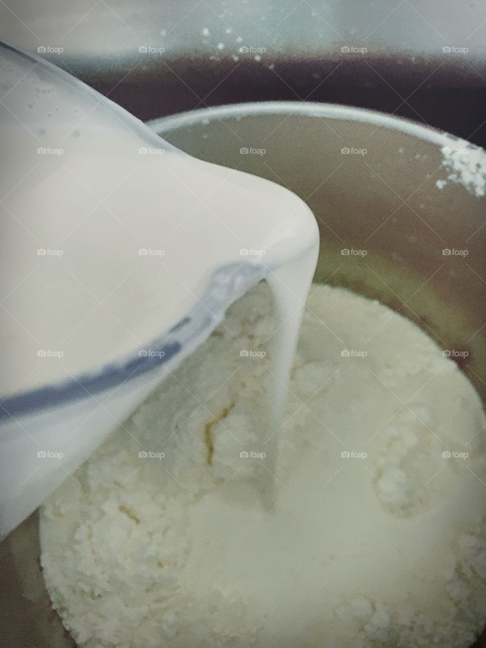 Let's Bake a Cake.   Heavy Cream is being poured into a mixing bowl containing a flour mixture.  