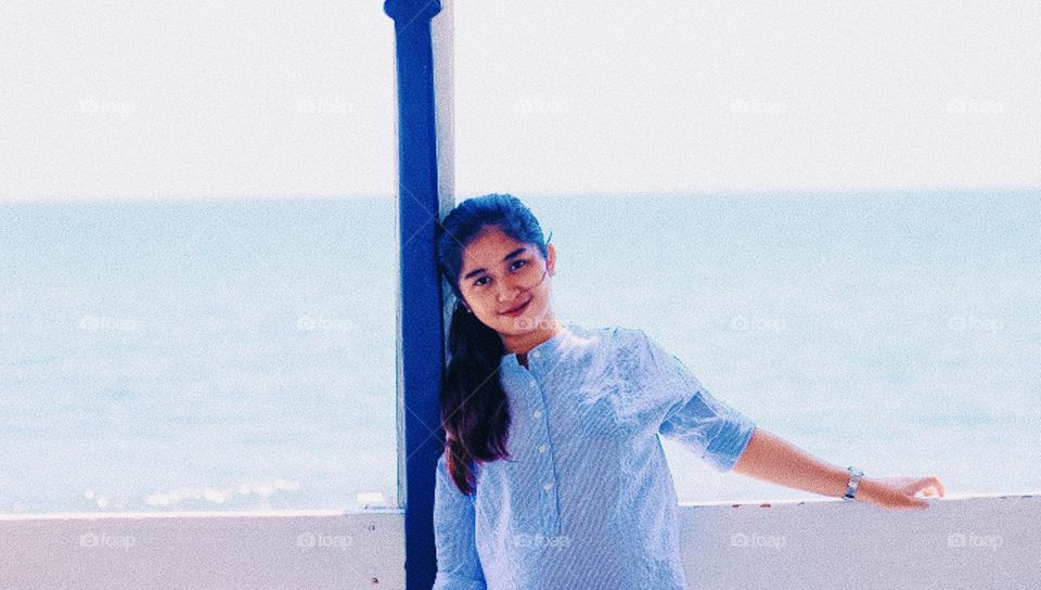 a smiling young girl near the beach