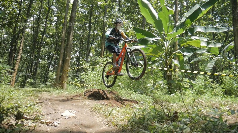 Mountain bike jumping on forest path