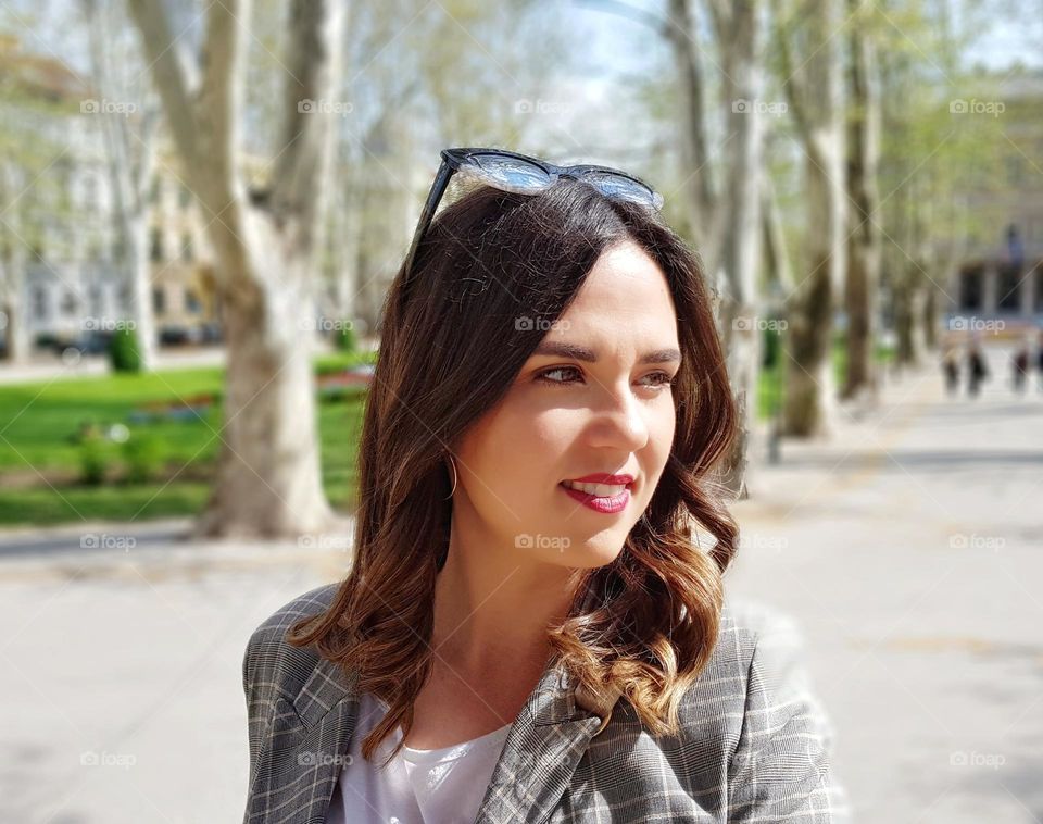 Portrait of beautiful young woman in park in city