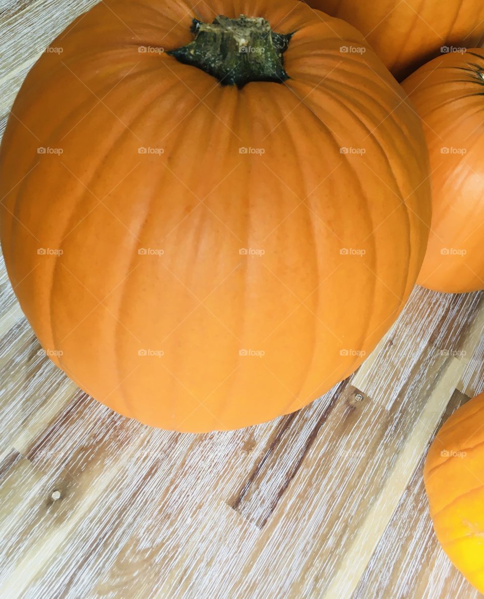 Beautiful, healthy, orange pumpkins. Sitting on a rustic table. Autumnal vibes.