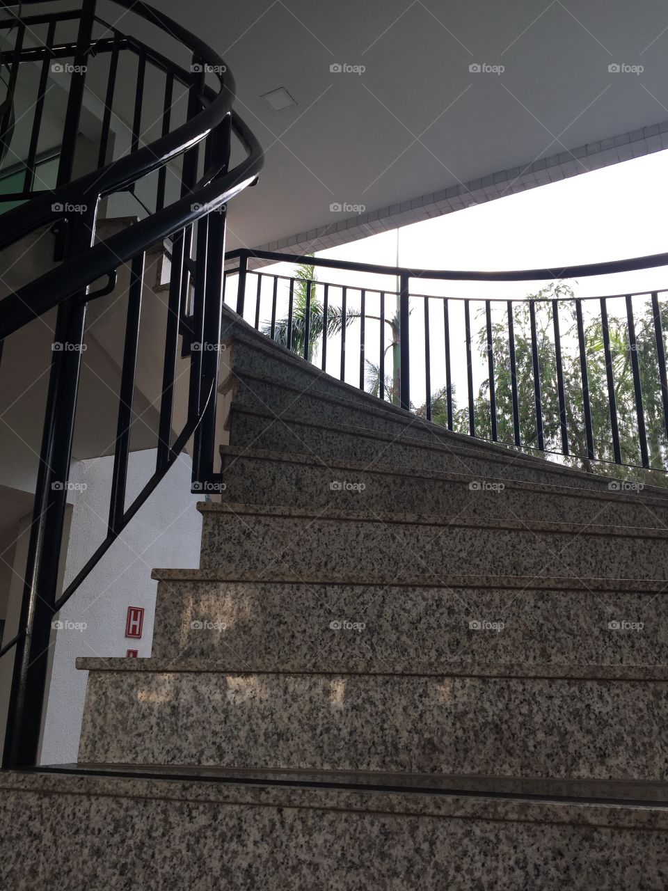 Granite staircase and black iron handrail.