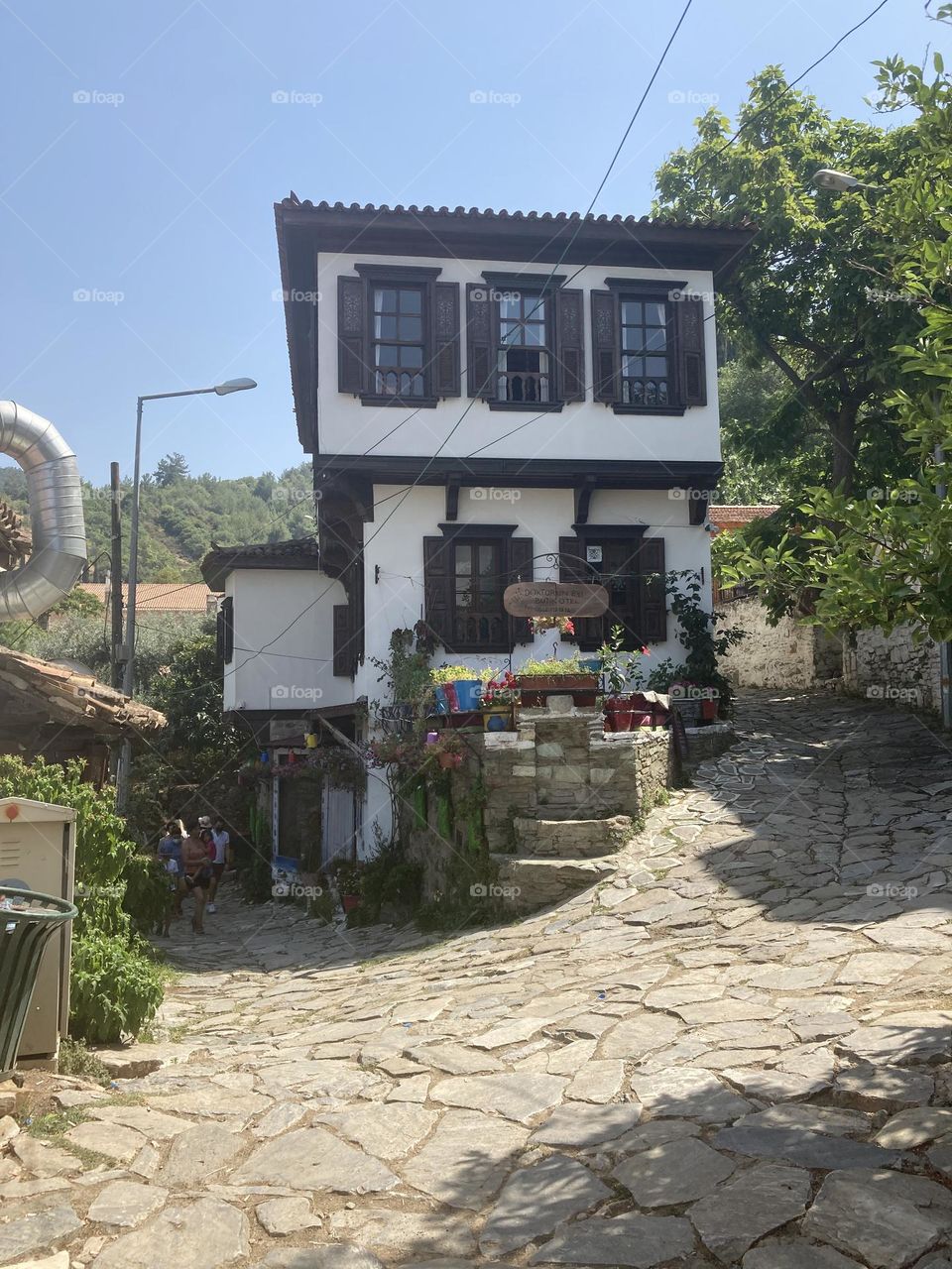 Greek village in Turkey. Blue sky and tall palm trees. Sunsets and sunny days. Summertime in Kusadasi. Vacation travel in Turkey . Summer view. Sunny day during vacation. Hidden gems and secret places.