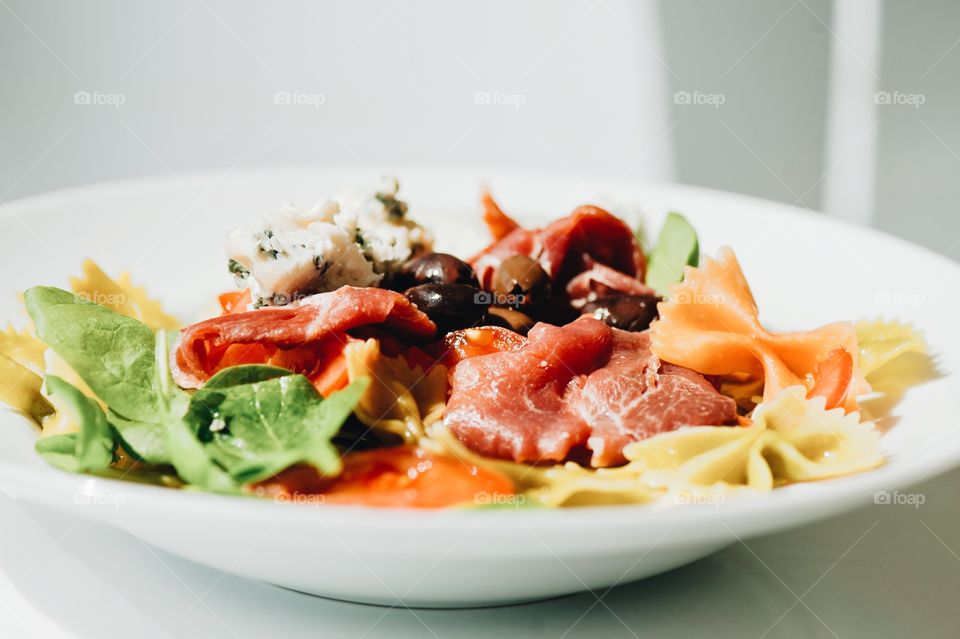 close-up of a young man eating a salad in a light kitchen