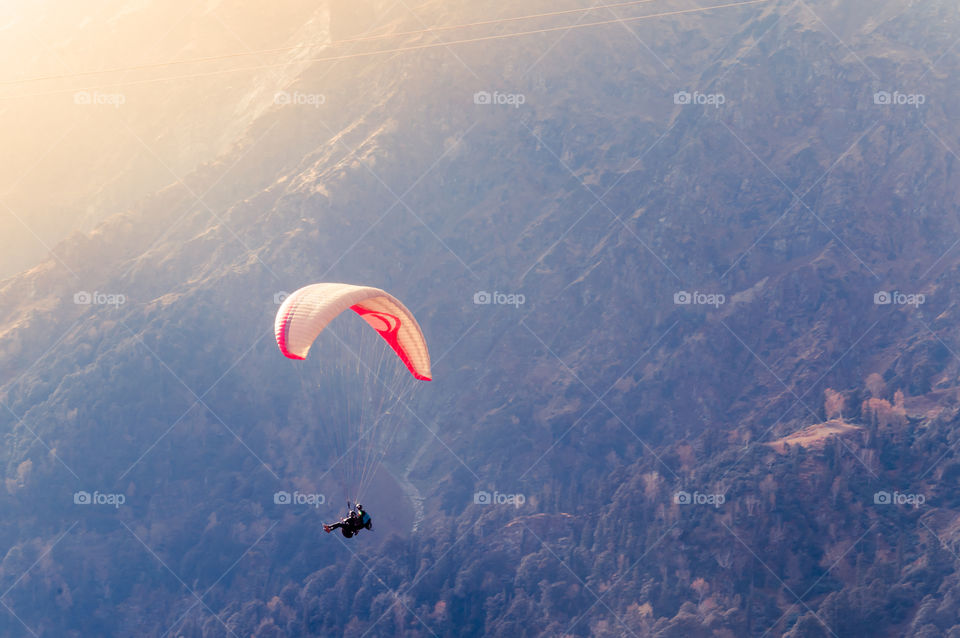 Close up of a Flying colorful parachute paragliding on beautiful mountain background. Solang Nullah, Kullu District, Manali Tehsil hill area, Himachal Pradesh, South Asia, India