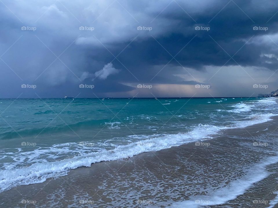 Storm clouds moving in over a beach at sunset