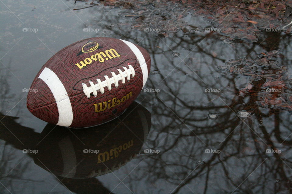 Reflection of football on puddle