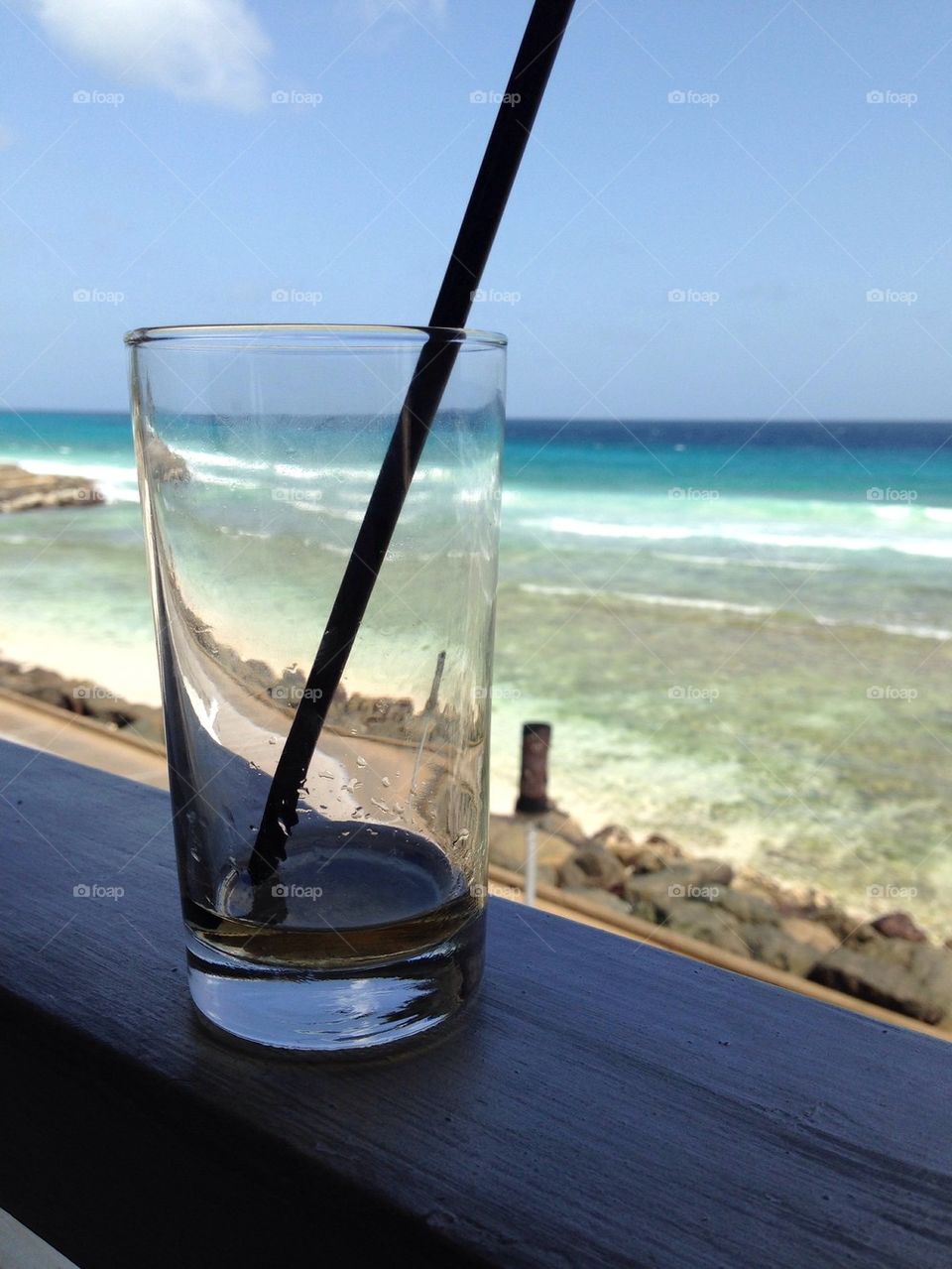 Empty drinking glass on sea shore bar 