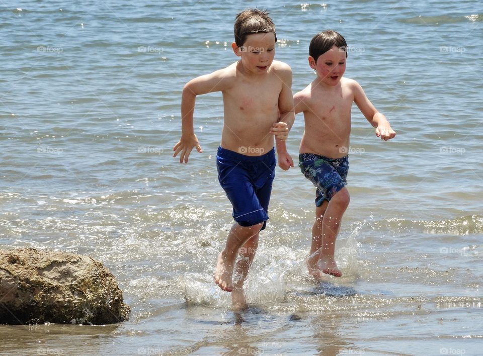 Young Runners. Young Brothers Running On The Beach
