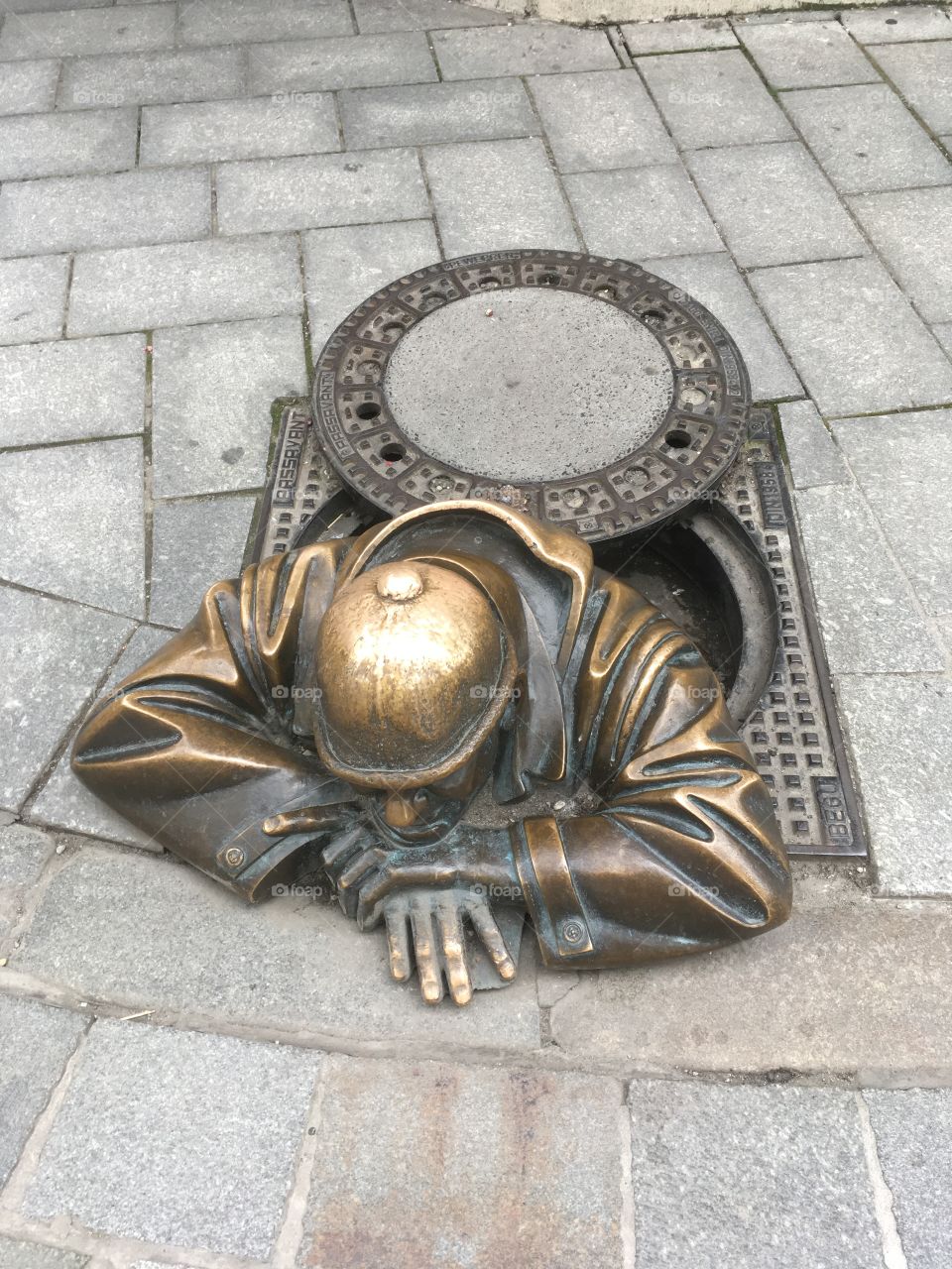 Bronze man in a manhole 