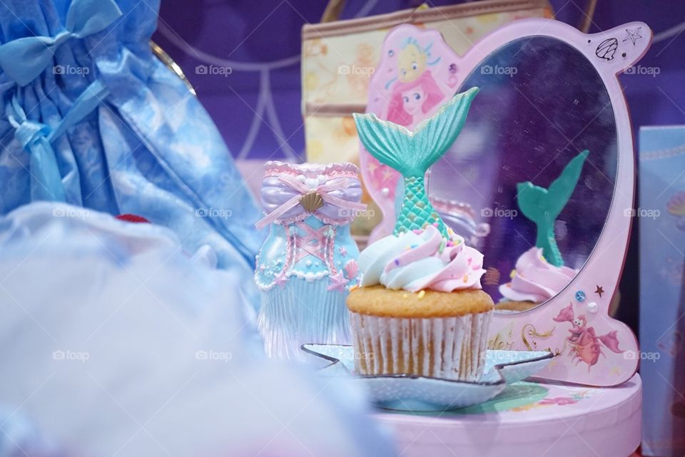 Mermaid cupcake. Buttercream cupcake with rainbow pastel whipping cream and mermaid tail on top. 