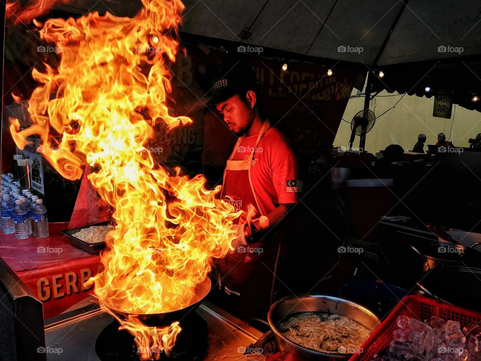 Flame On! Local chef cooking the famous char kuey tiaw, a flat rice noodle, on a high flame at the Malaysian and Thailand Food Festival