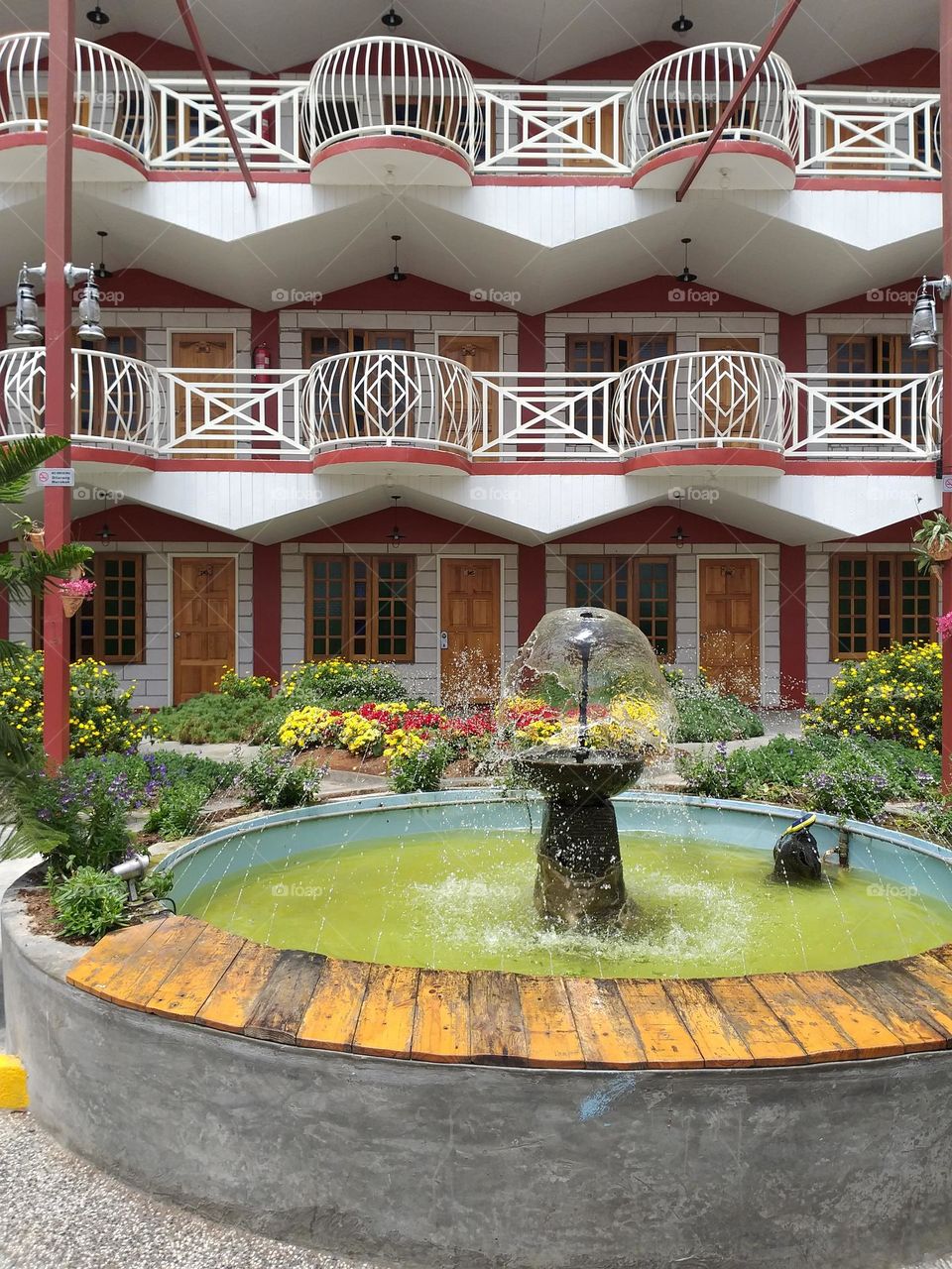 In front of the hotel building there is a beautiful garden. Fountain decoration in the garden.