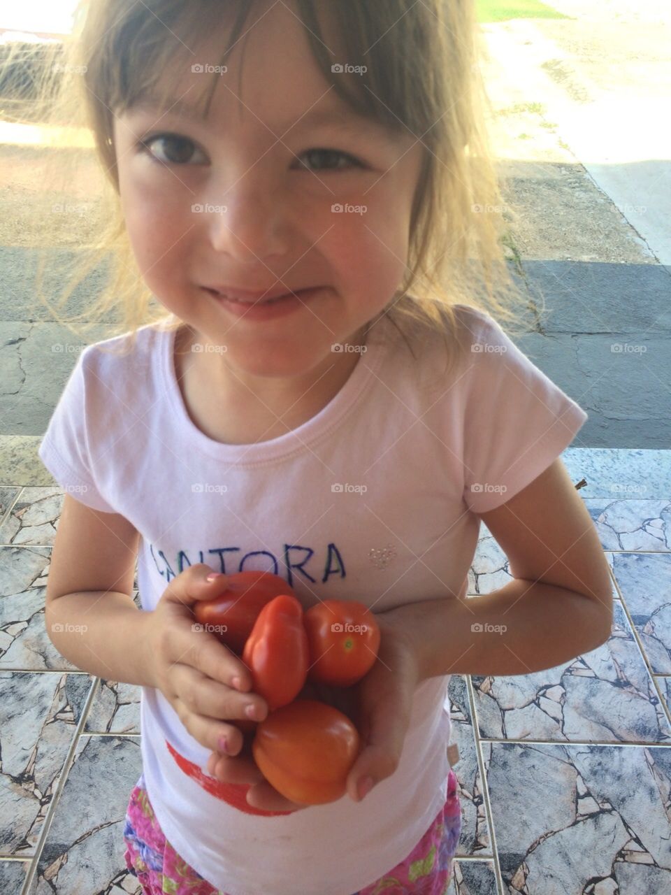 Alguém colheu tomatinhos plantados na horta da própria casa. Nosso jardim tem flores e frutas!