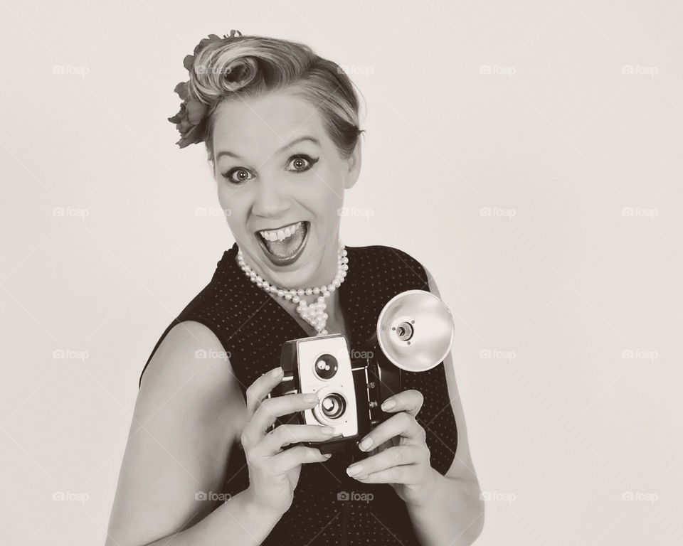 Portrait of a woman holding retro styled camera