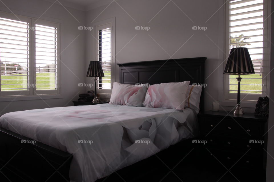designer bedroom suite with rose patter duvet and gold and black lamps