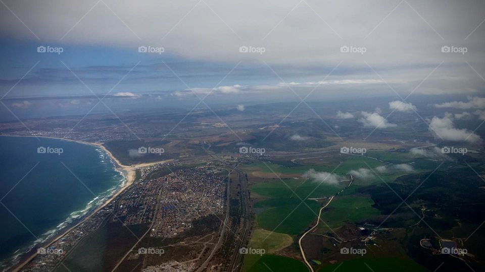 A bird’s view of the Earth. On a plane flying over the ocean close to landing 