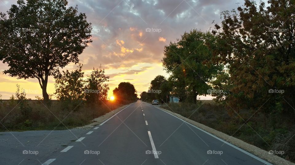 Asphalt road toward the sun