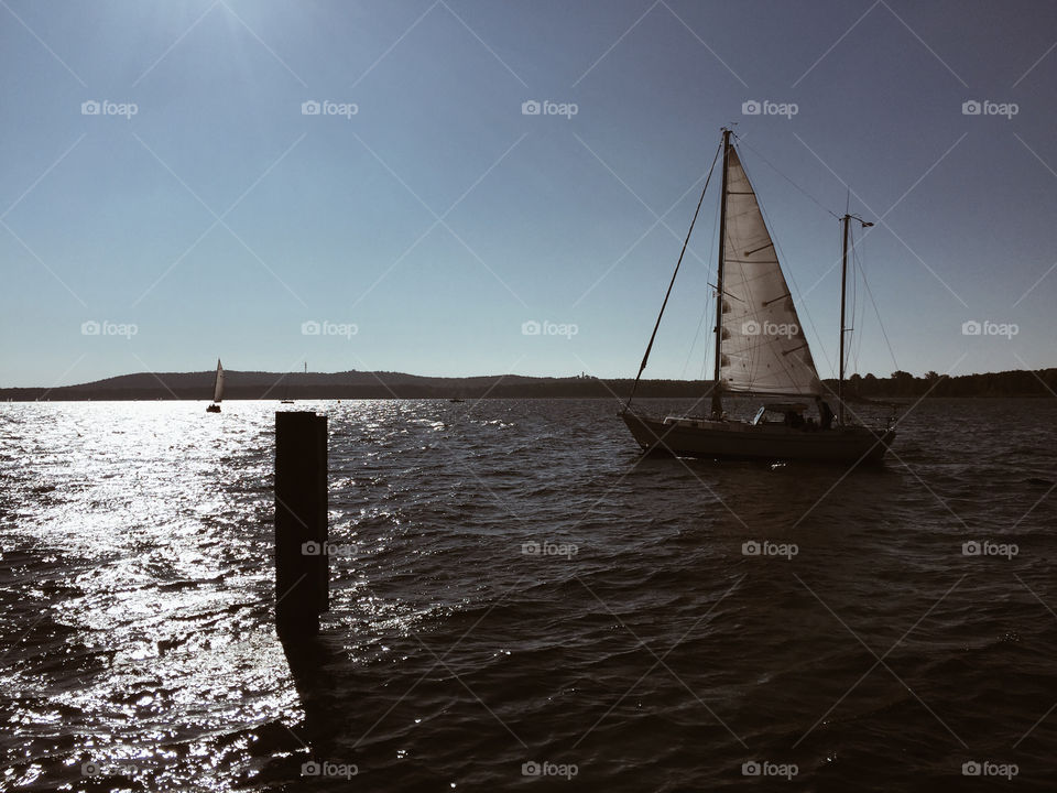 Sailboat on lake in autumn. Sailing boat on lake in sunny autumn weather