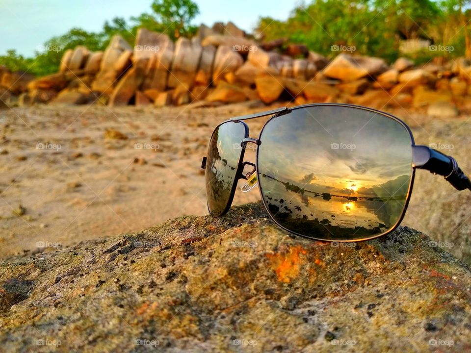 Sunset beach through the glasses lens