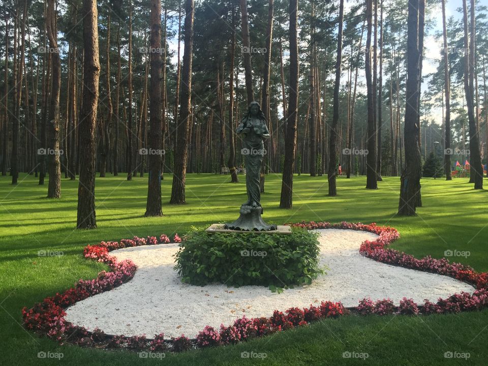 Metallic statue of a woman in a park