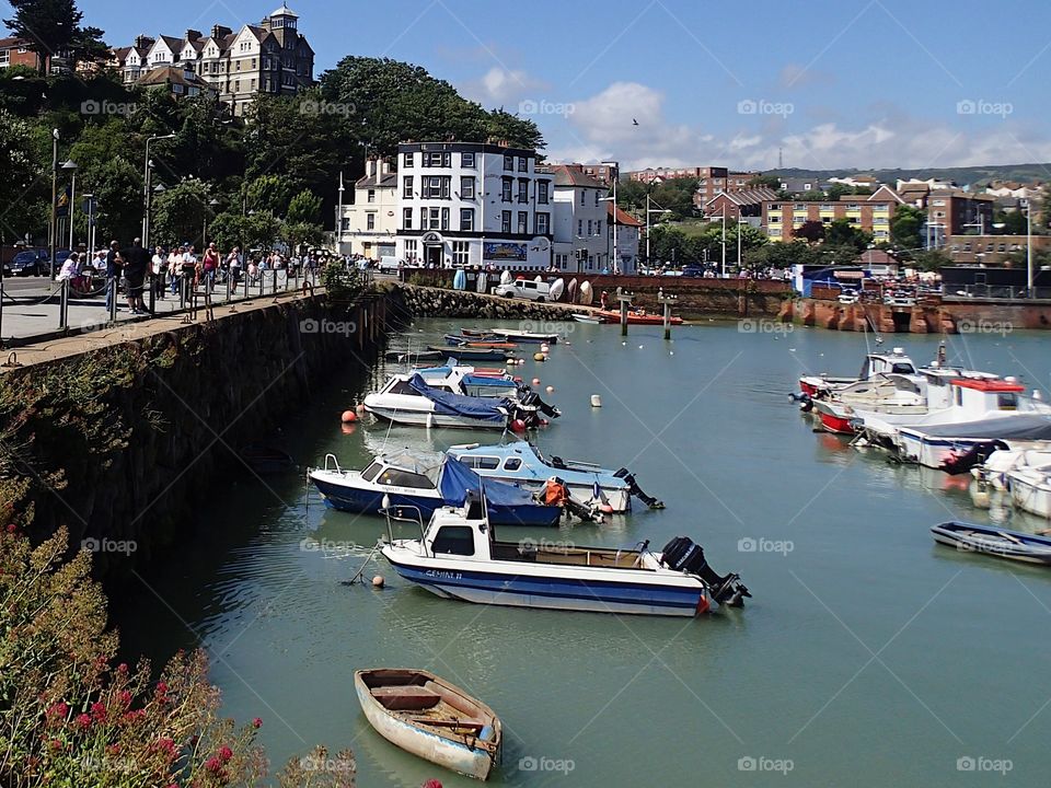 Tourists enjoy a sunny summer day along the bay while on vacation in Folkestone in England 
