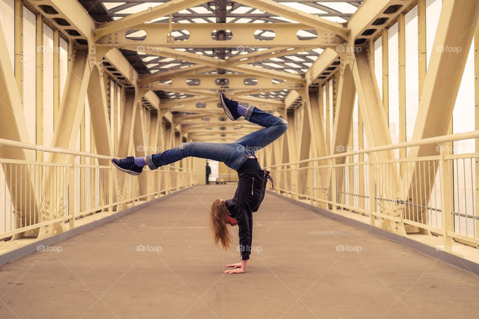 Be in shape in the city. Girl is doing handstand in the city street