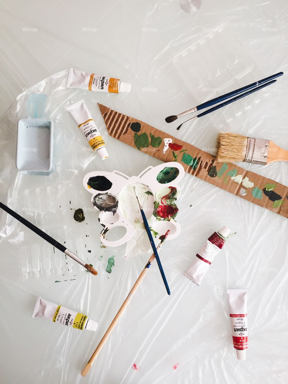 Palette with paints and brushes on the table